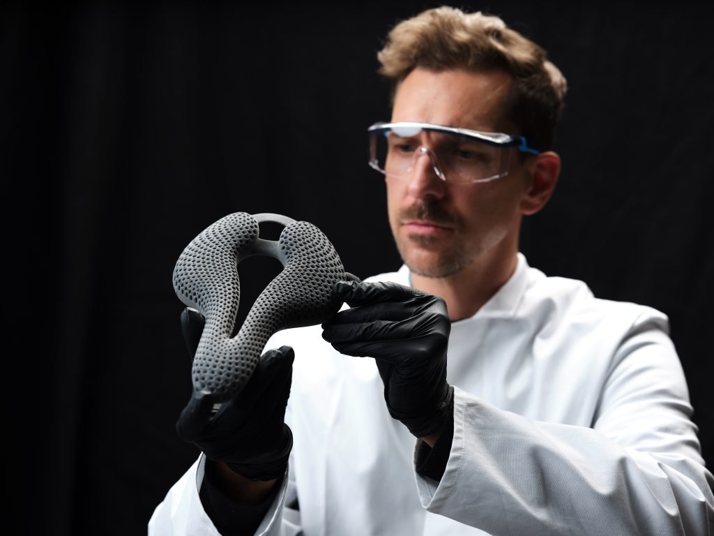 BASF TPU Material Bike Saddle Man with glasses holding a MJF TPU material bike saddle 3d printed