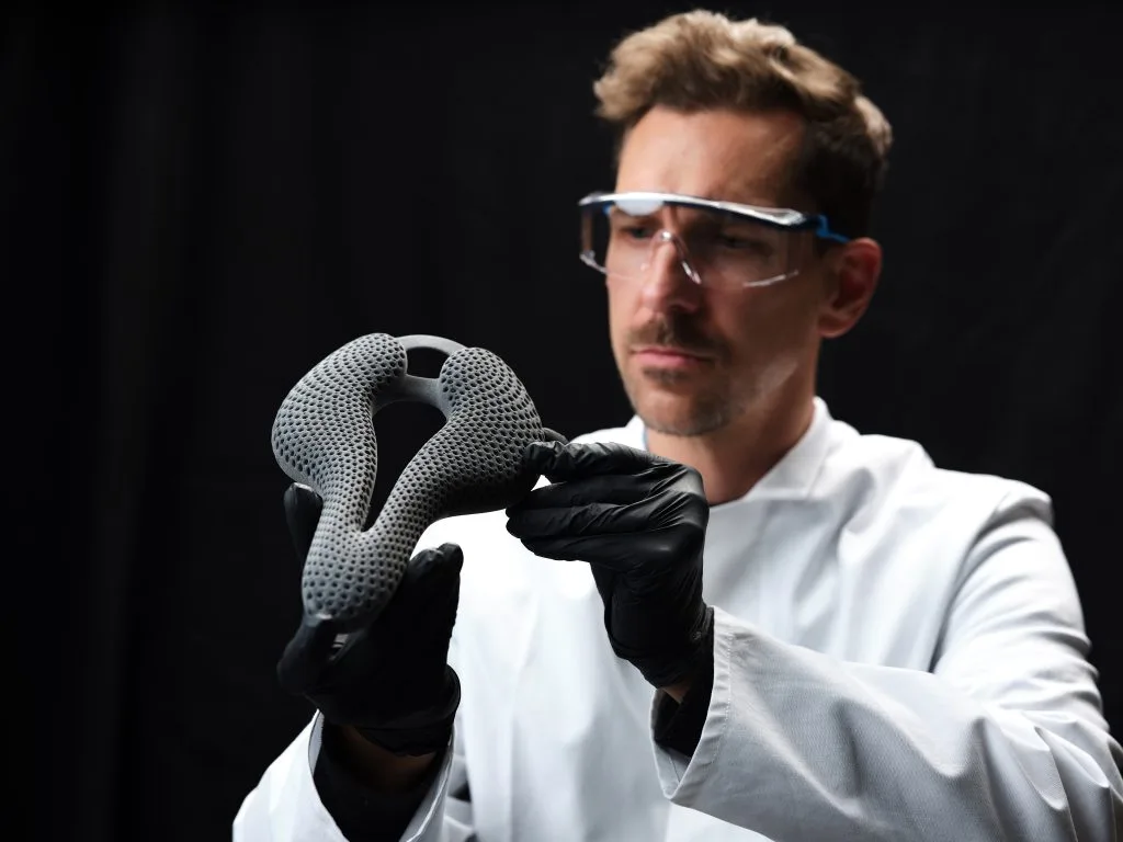 BASF TPU Material Bike Saddle Man with glasses holding a MJF TPU material bike saddle 3d printed