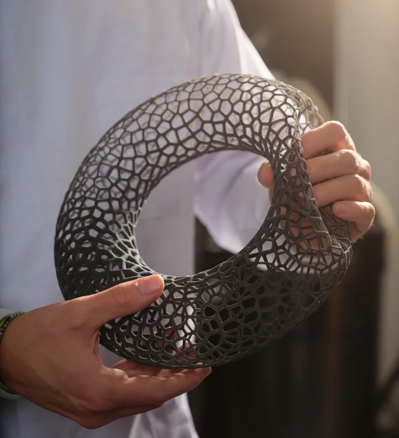 Benefits of Multi Jet Fusion Man holding thermoplastic polyurethane (TPU) 3D printed part