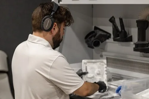 Endeavor 3D employee working at a MJF 3D printing depowdering station