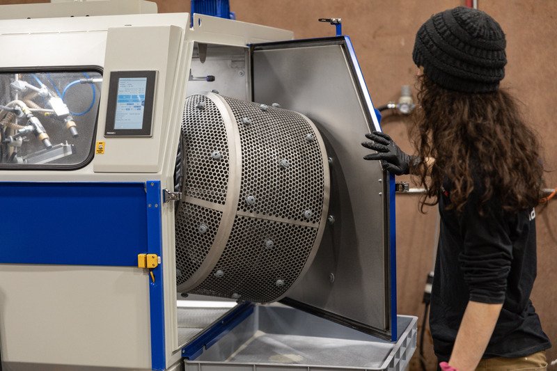 Endeavor 3D employee working a post processing surface machine